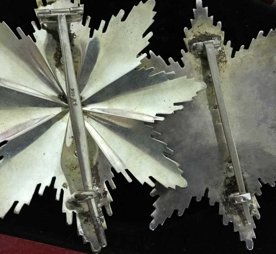 Figure 3: needle and reverse design comparison between 1st type to the right and one of the 2nd types to the left. Two Grand Cross stars.